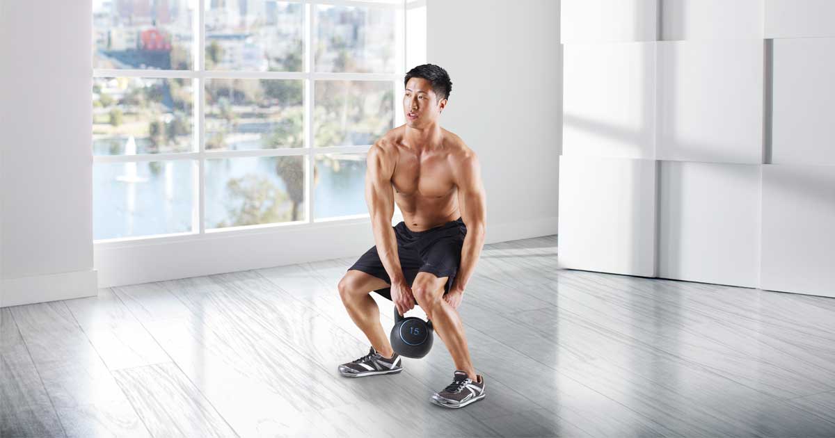 man in room using a Gold's Gym Kettlebell