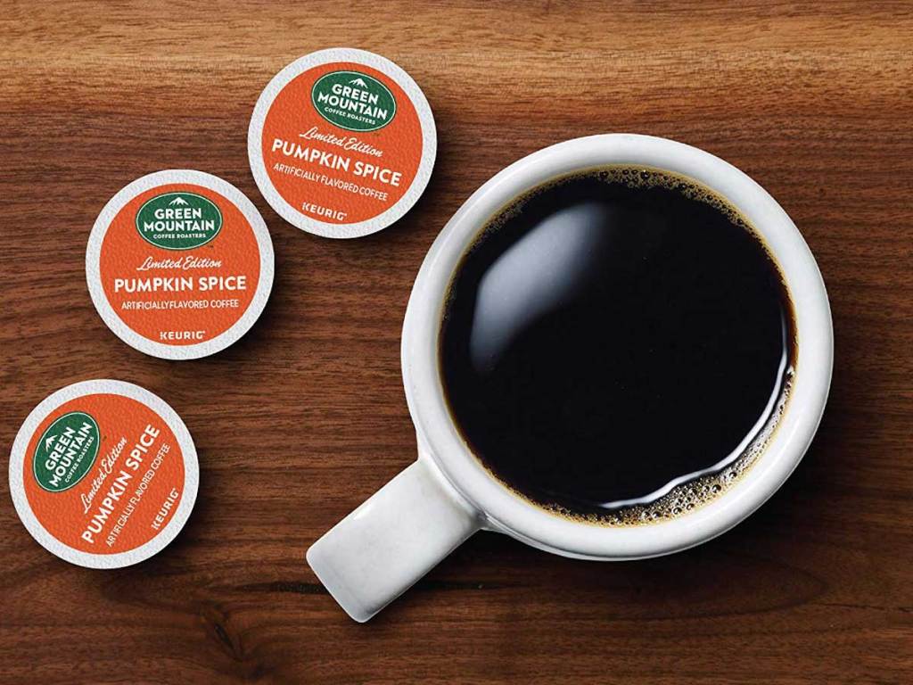 white coffee cup with Green Mountain Roasters Pumpkin Spice K-Cups sitting next to it on a wood surface