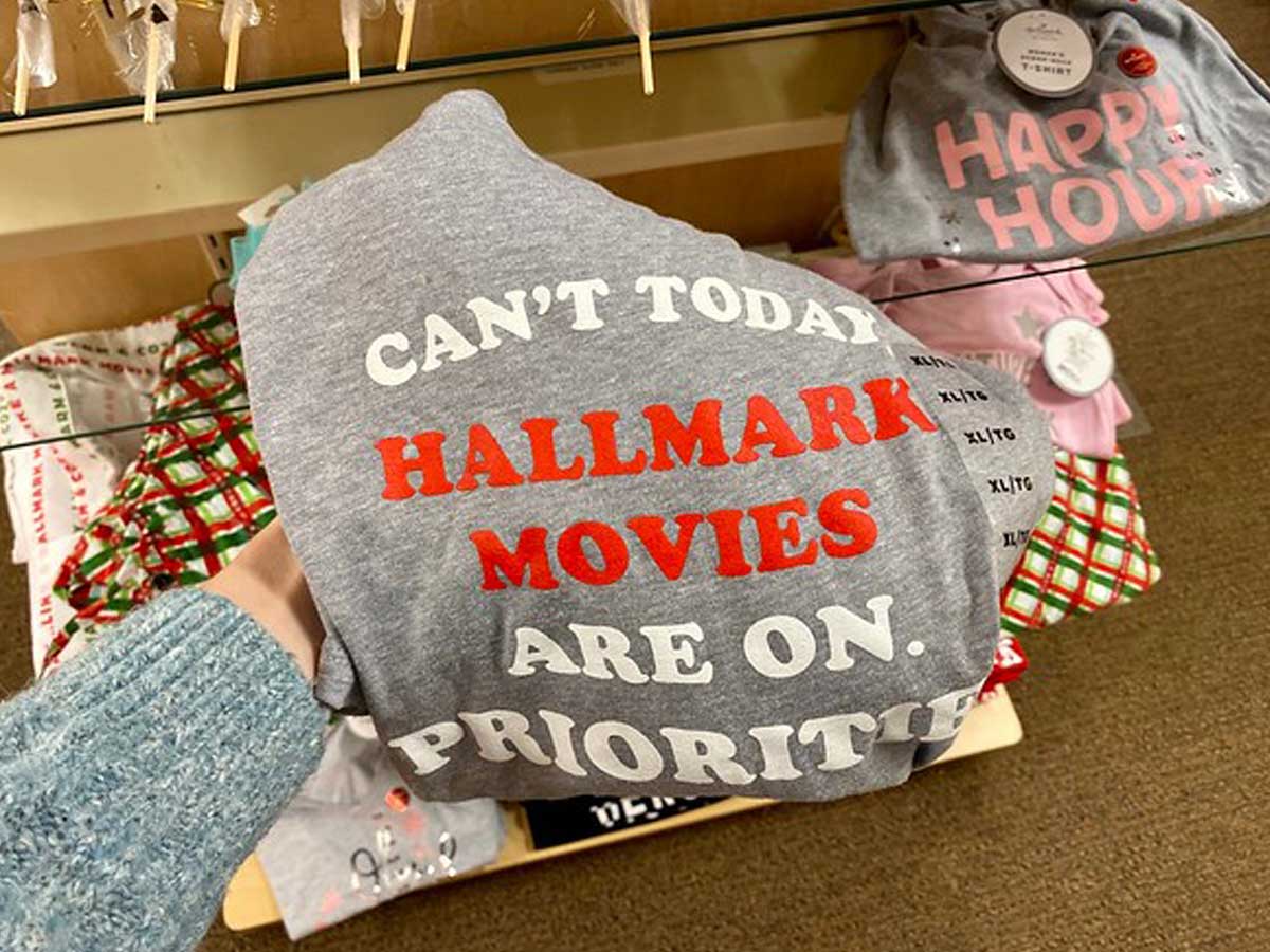 woman holding a can't today hallmark movies are on priorities t-shirt