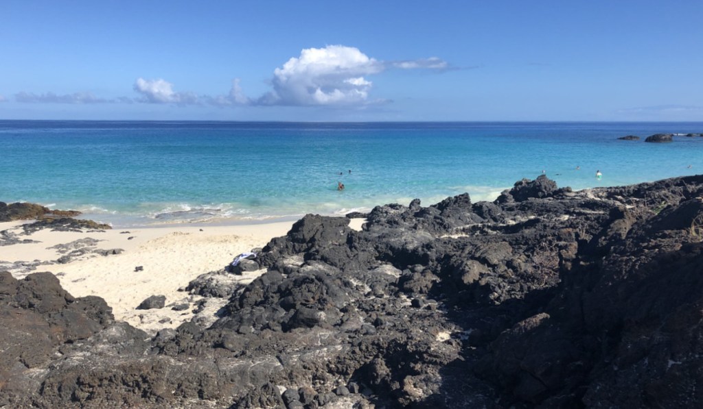rocks behind beach in hawaii