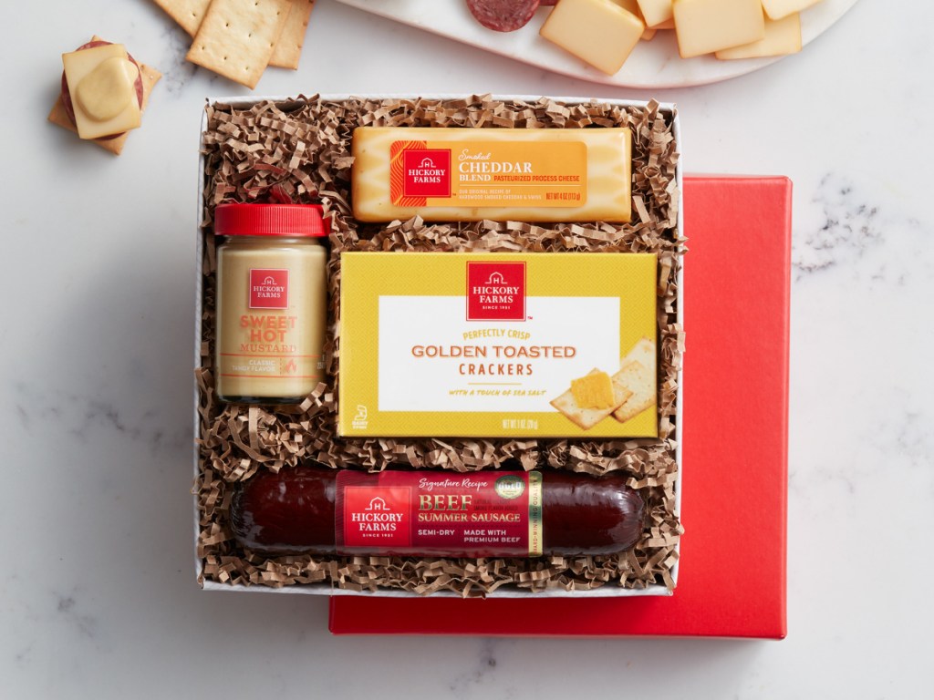 crackers, mustard, cheese and sausage gift box on marble table
