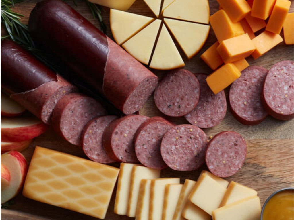 summer sausage, crackers and cheese on a wood baord