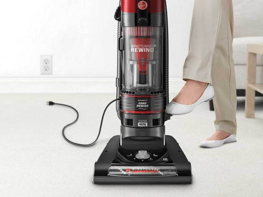 woman standing next to Hoover WindTunnel 2 Rewind Pet Upright Bagless Vacuum