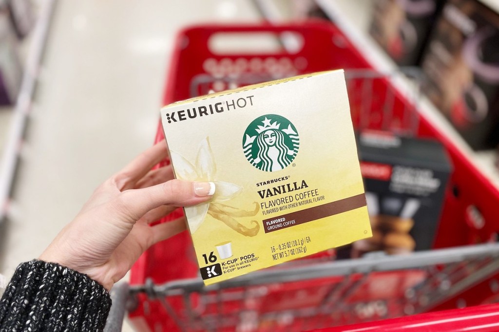 hand holding a box of starbucks k-cups with red target cart