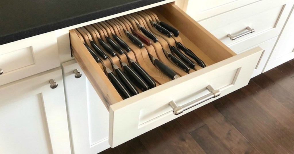 knife block in white cabinet drawer with black countertop