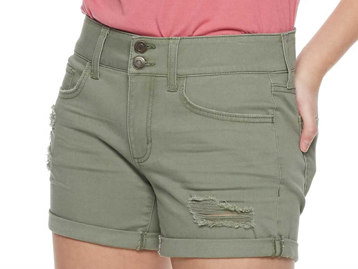 model wearing a pair of olive green juniors' so 2 button denim midi shorts from Kohls