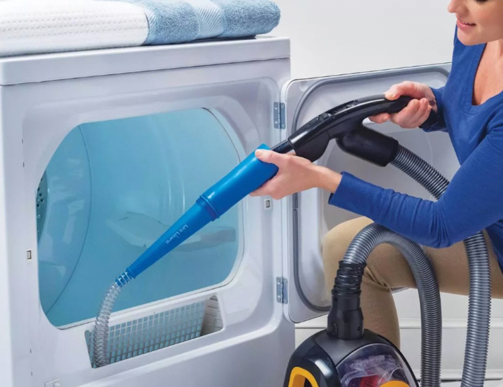 person using hose and vacuum on dryer lint compartment