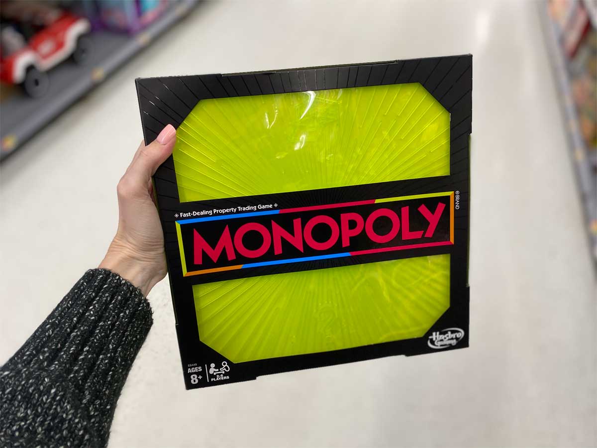 woman holding Monopoly Neon Pop Board Game in a store