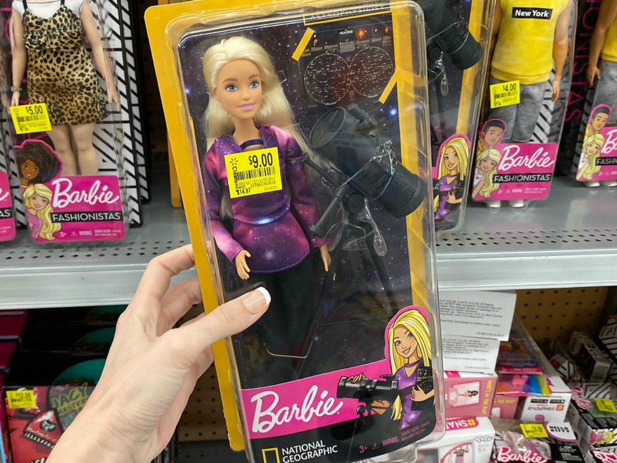 hand holding Barbie doll in packaging