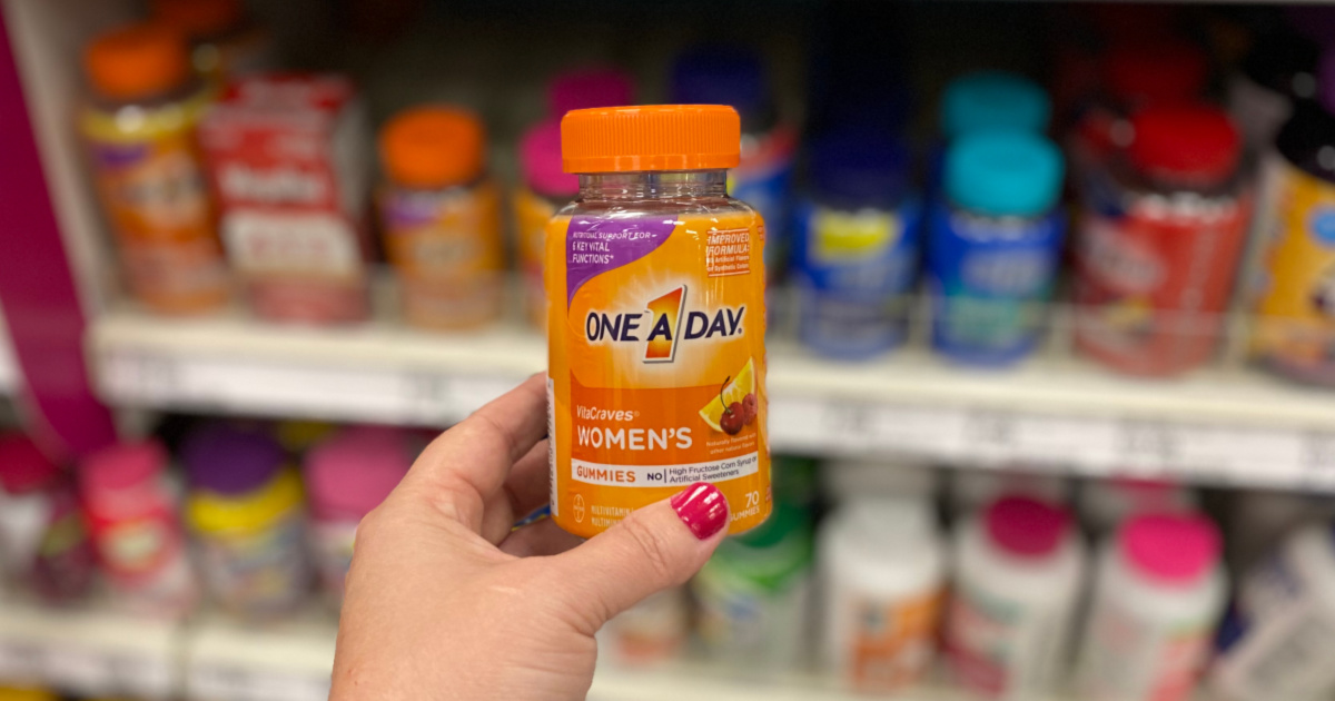 hand holding one a day women's vitamins with blurred background