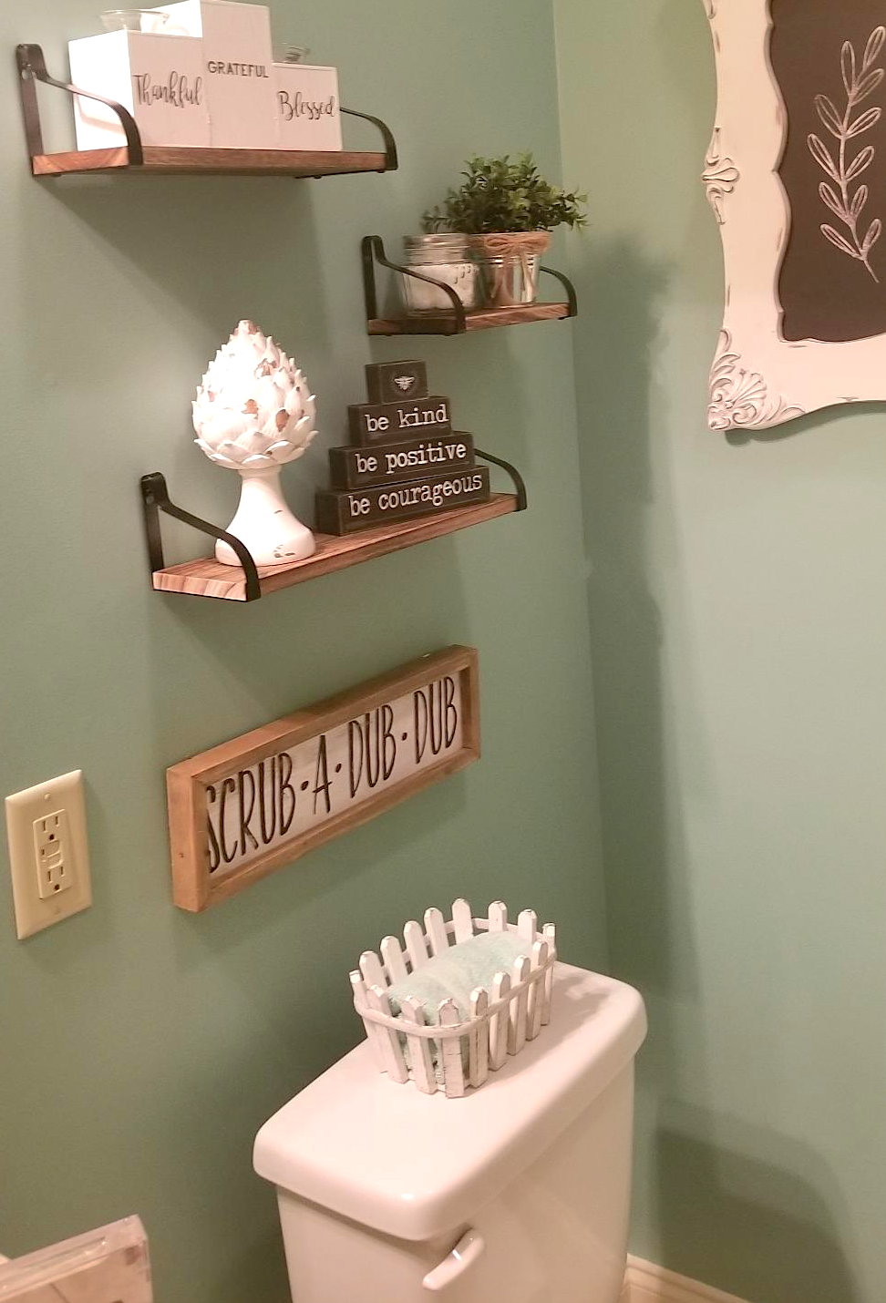 open shelving displayed in bathroom with decorative signs