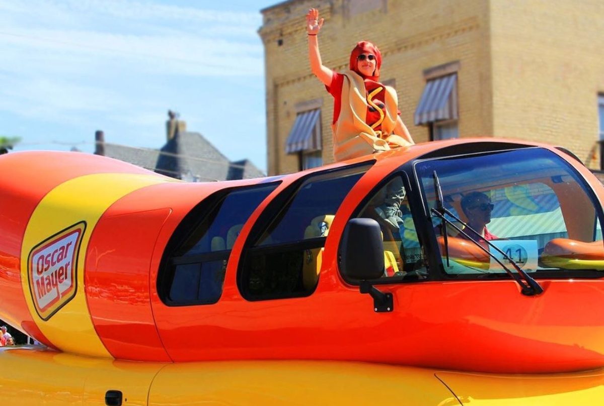 man in hot dog costume riding on Weinermobile