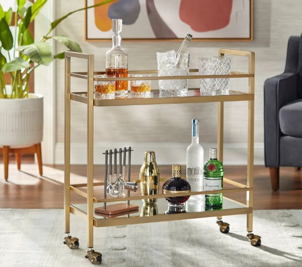gold bar cart filled with drinks and drinkware