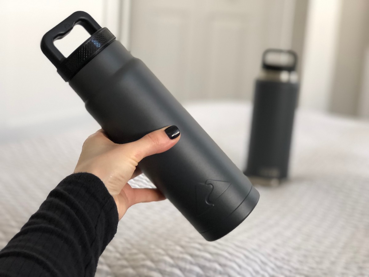 hand holding dark gray ozark trail water bottle