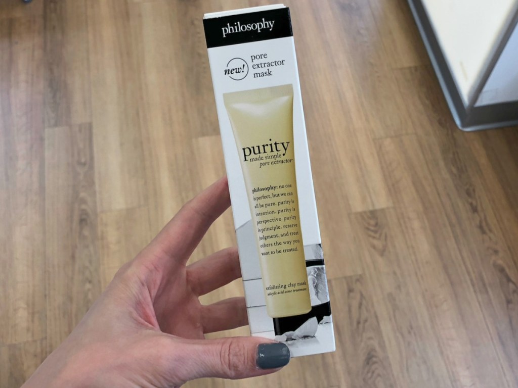 clay mask in a tube in package in hand at beauty store