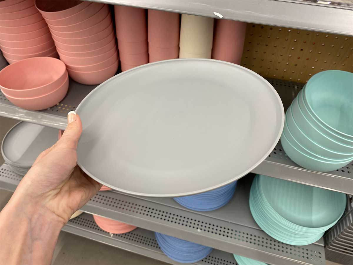 woman holding a Mainstays 10.5 inch gray plastic plate in the store