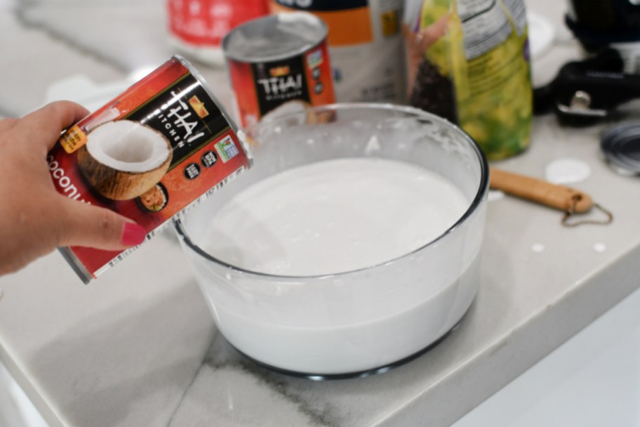 pouring canned coconut milk out in a bowl