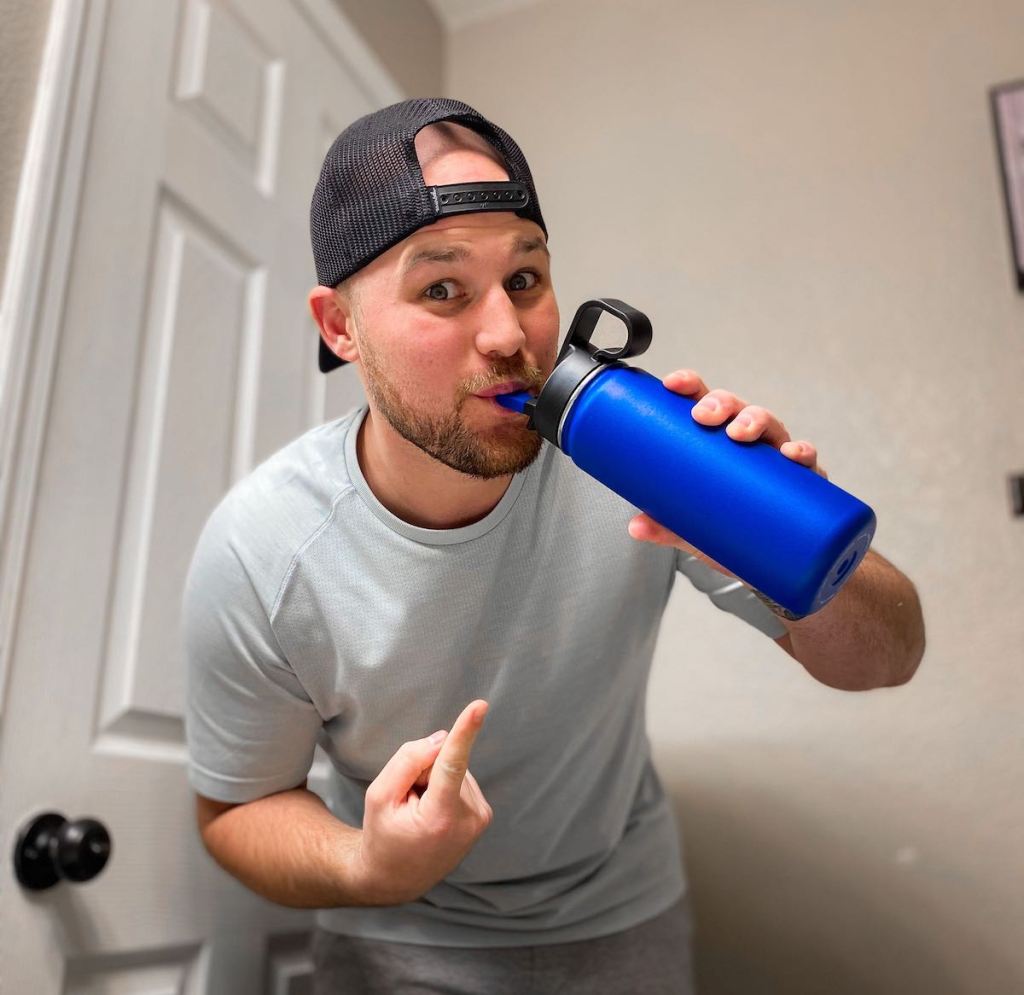 man sipping from straw on blue reusable water bottle