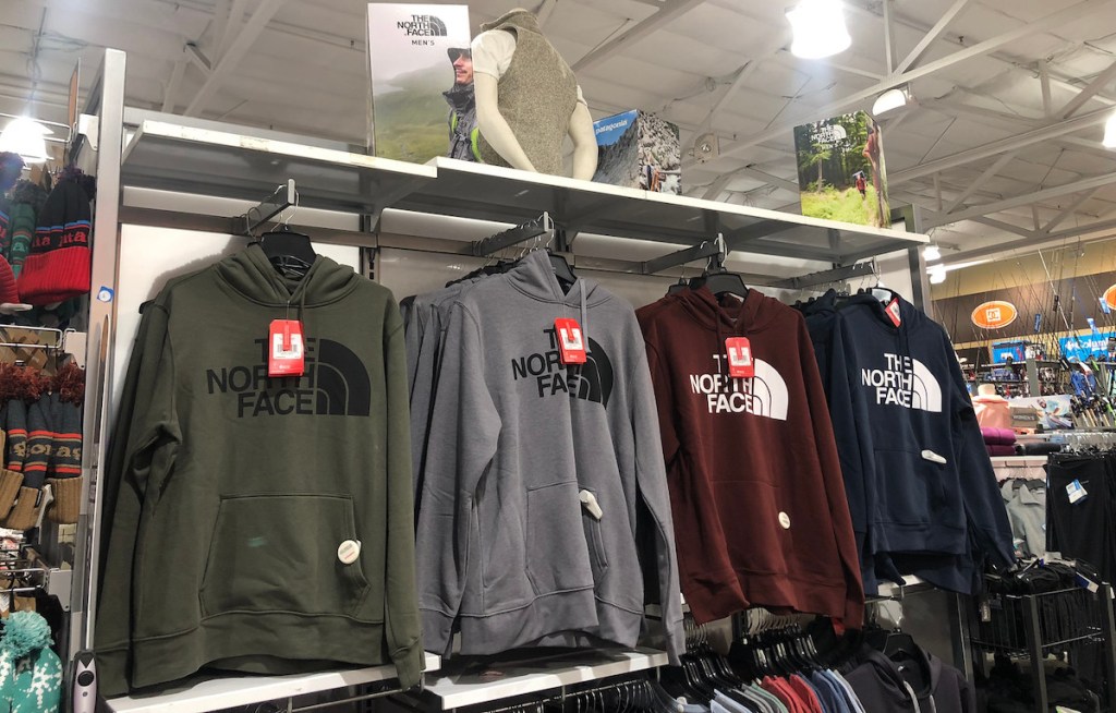 row of sweatshirts hanging on store shelf 