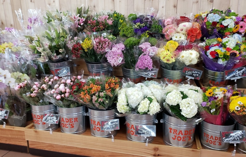 rows of bouquets of flowers in trader joes store buckets