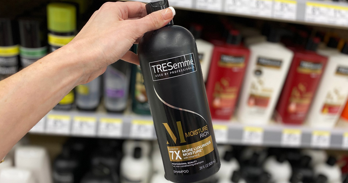 person holding tresemme shampoo