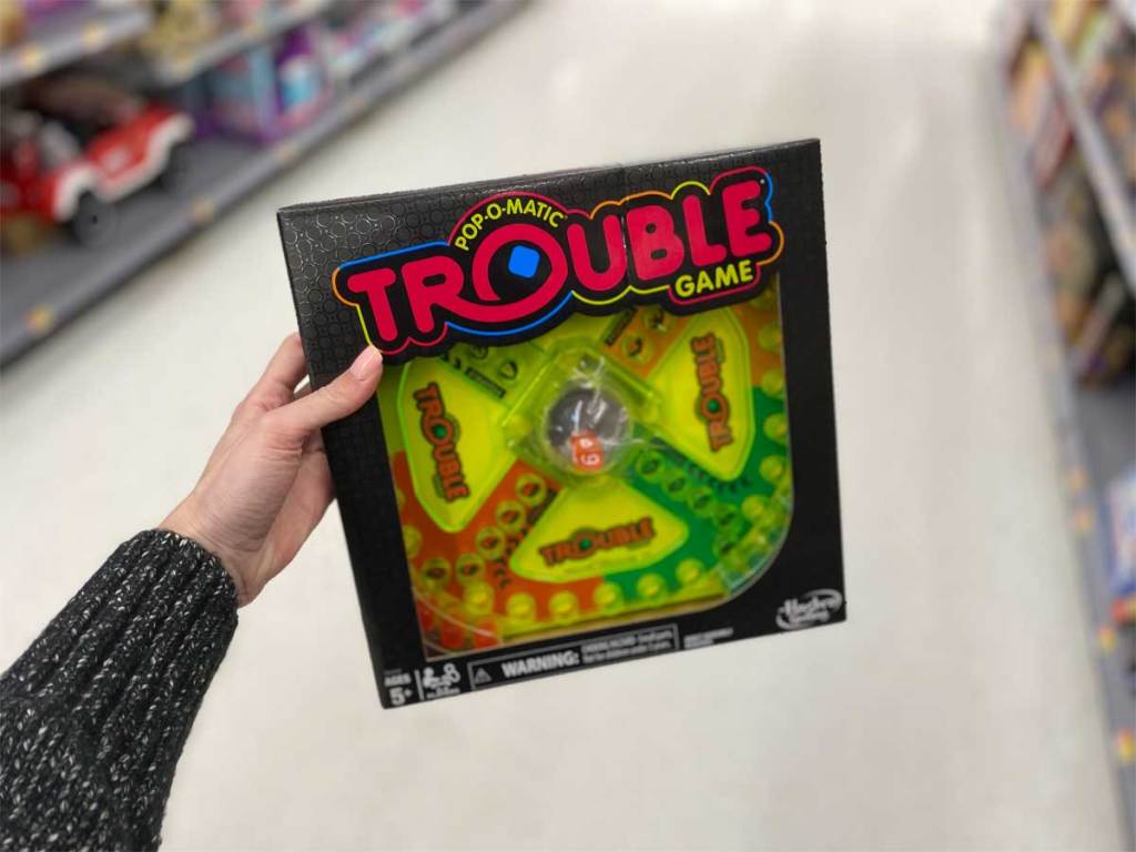 woman holding Trouble Neon Pop Board Game in a store