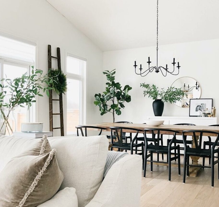 Chandelier permeated in the decoration of a dining room table and a pottery barn hanging on a chair