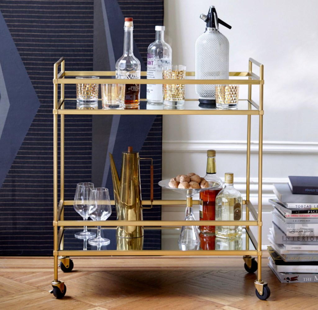 gold bar cart filled with drinks and drinkware