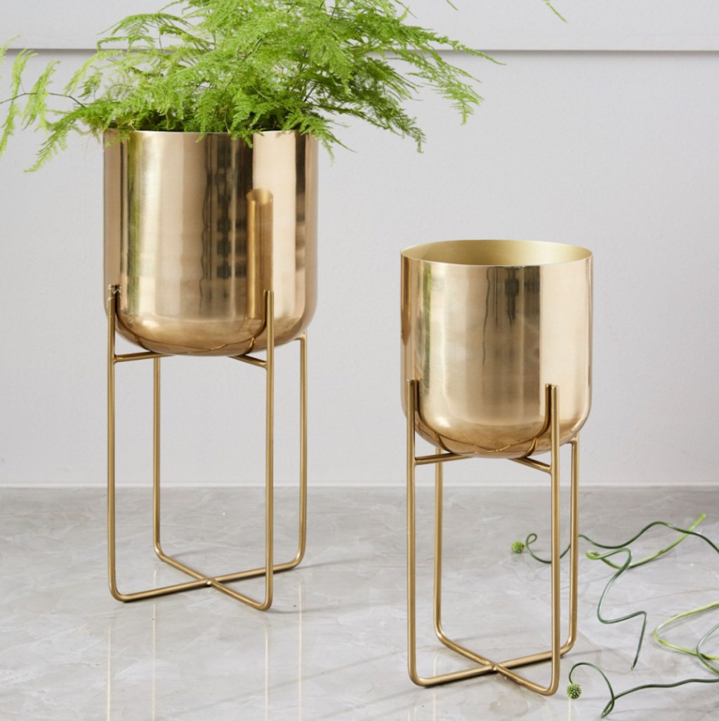 gold metal planters sitting on floor