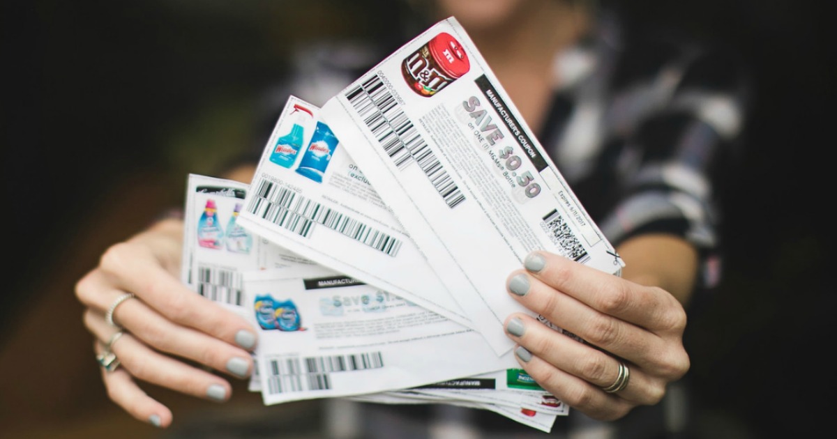 hands holding stack of printed coupons