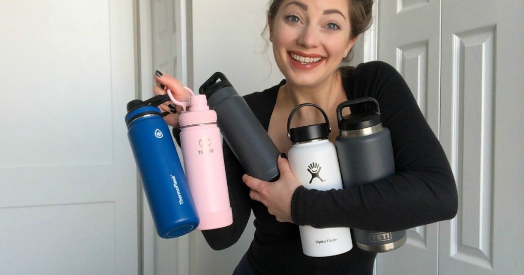 woman holding five water bottles