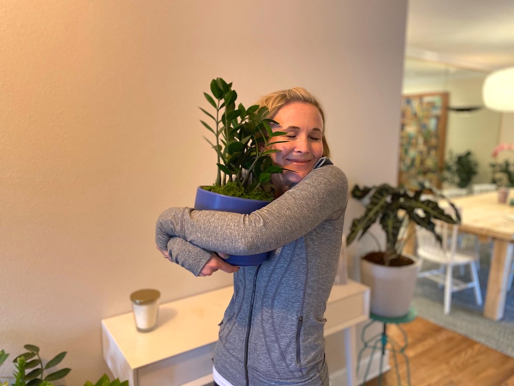 woman hugging house plant 