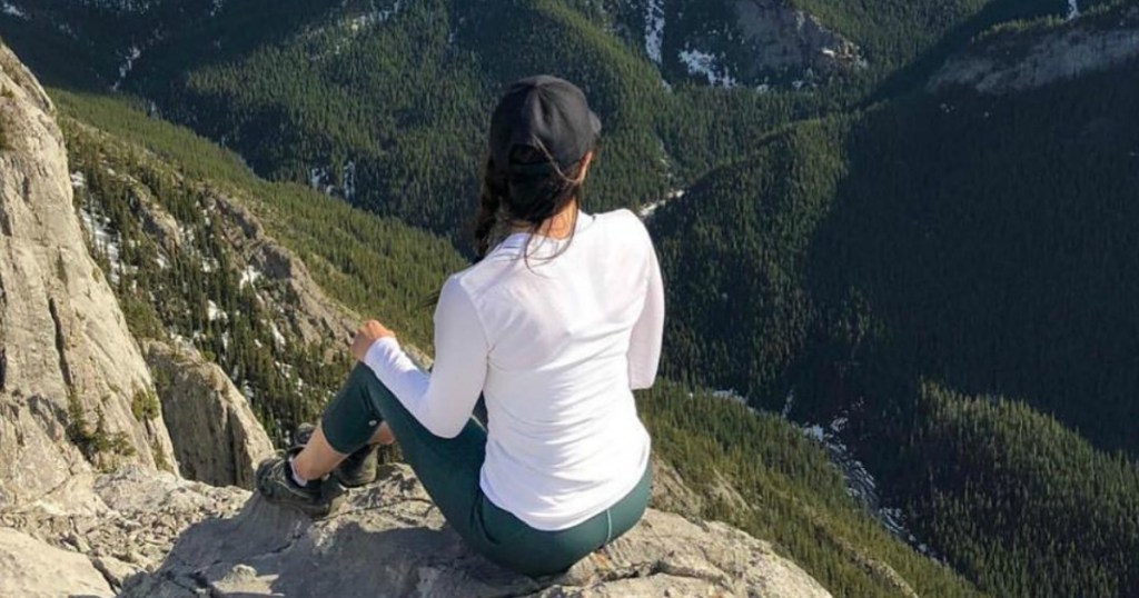 woman sitting on top of mountain