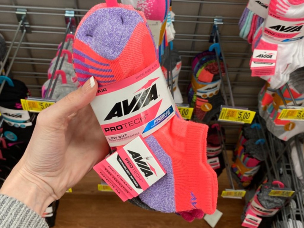 Woman holding pack of socks in store