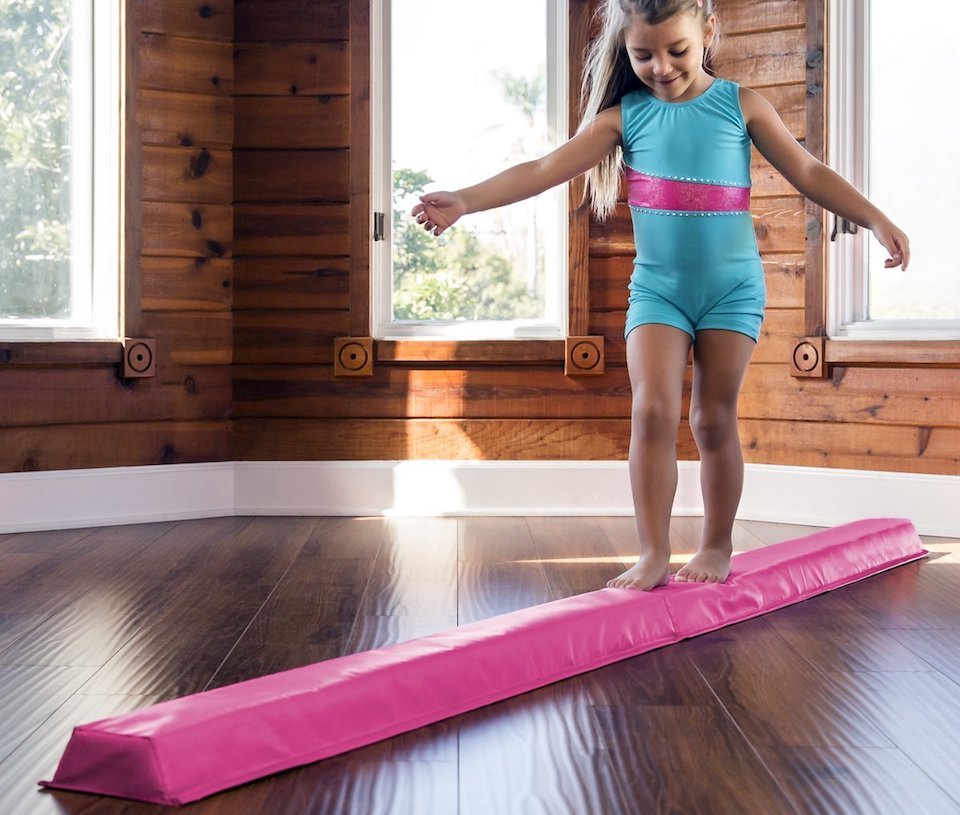 girl walking on a pink balance beam