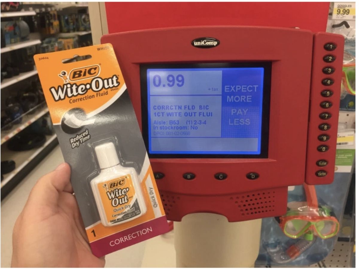 hand holding package of wite out next to price checker at Target 