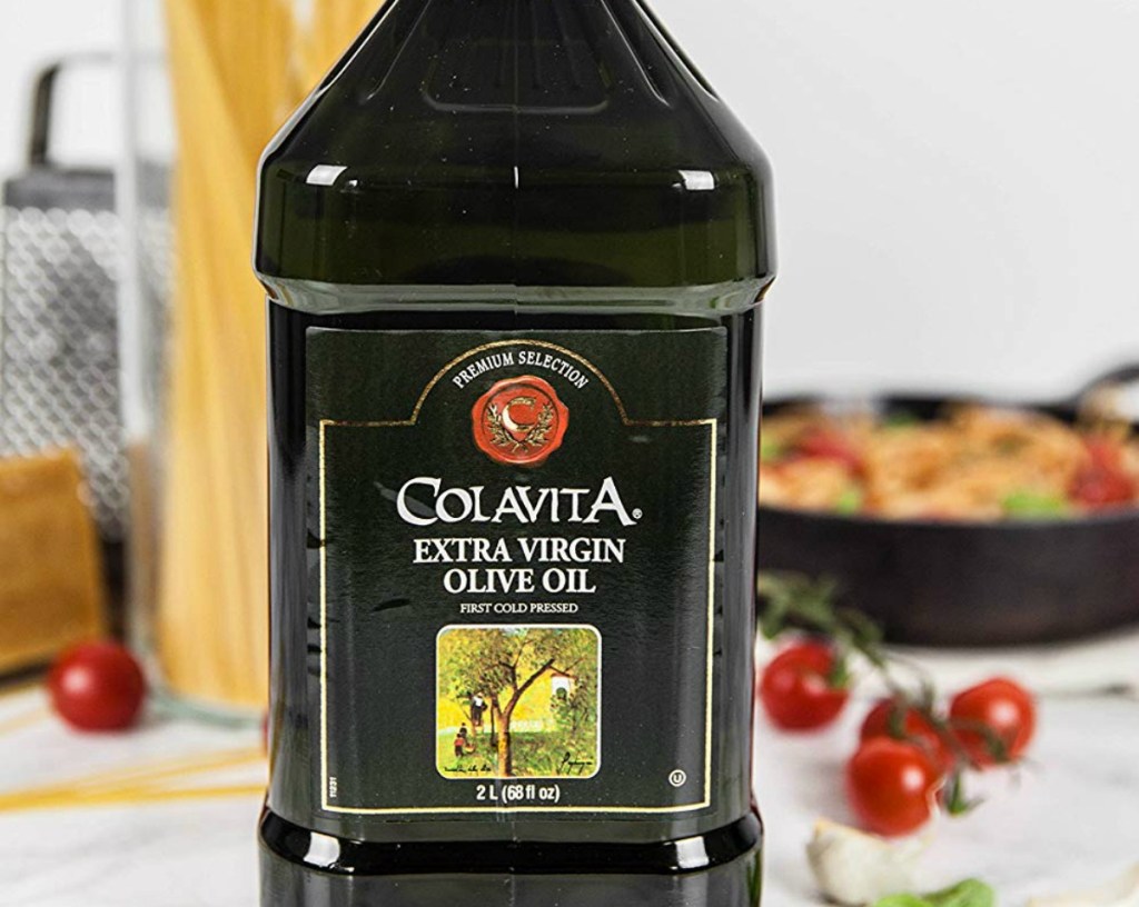 Colavita extra virgin olive oil bottle in front of a pan of food