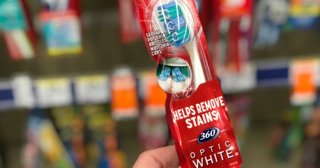 hand holding a Colgate optic white 360 toothbrush