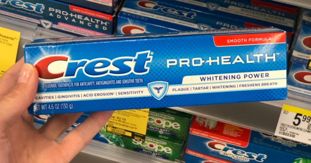 hand holding crest toothpaste at walgreens