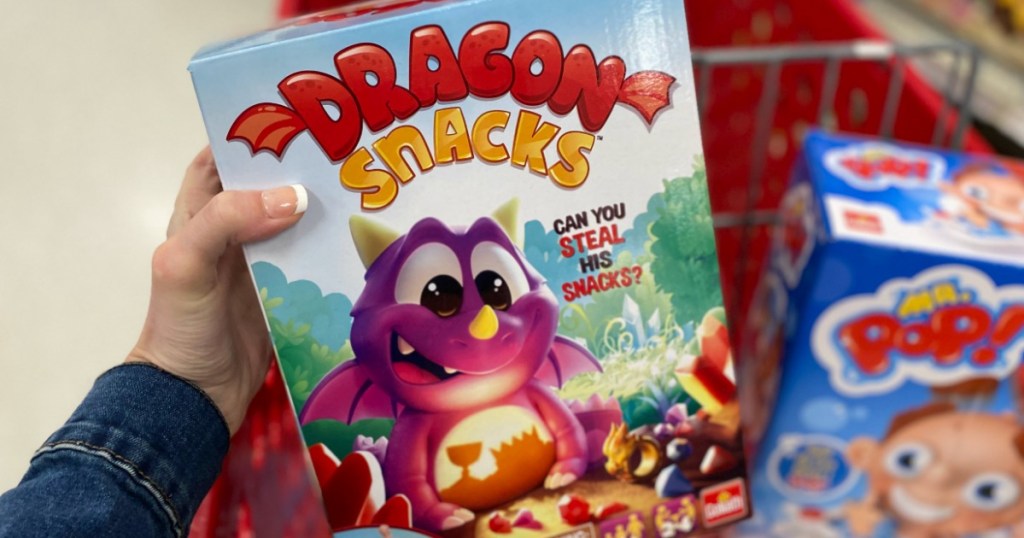 hand holding Dragon Snacks game box by Target cart