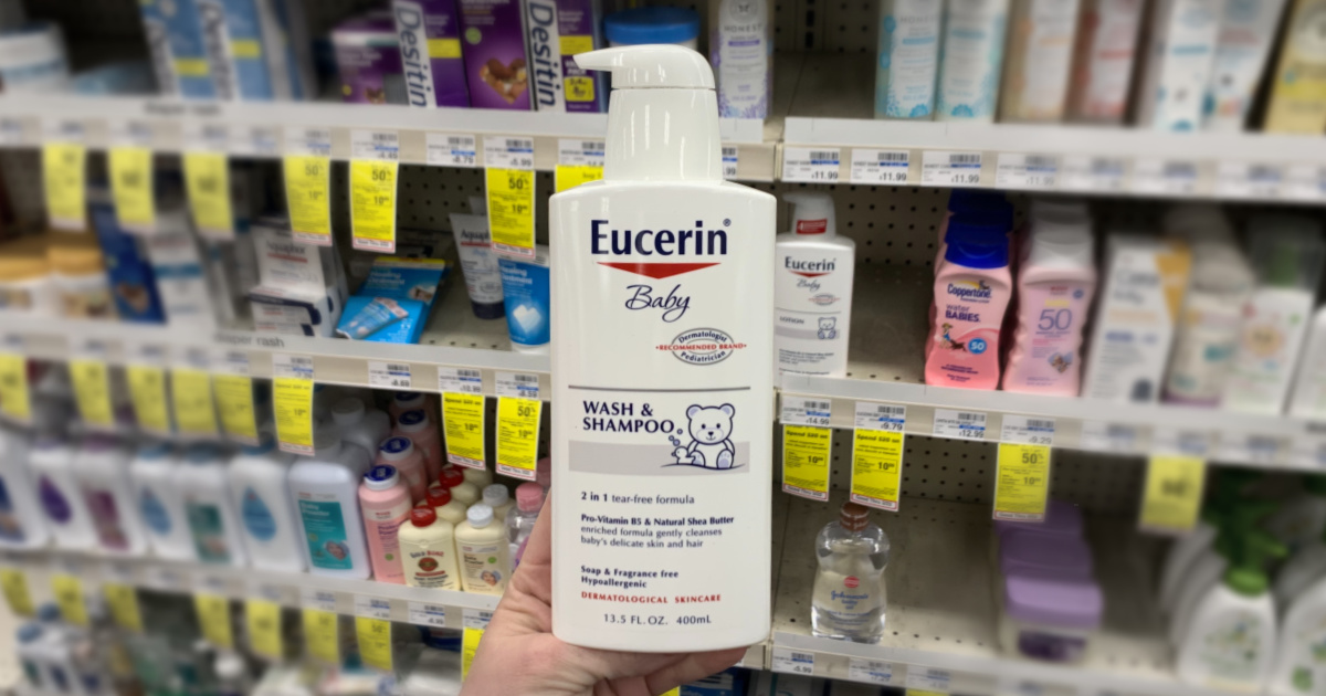 Hand holding Eucerin baby wash in front of shelf 