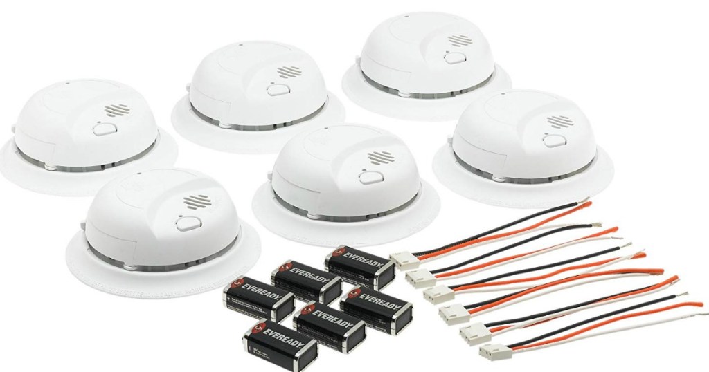 six smoke detectors lined up with batteries