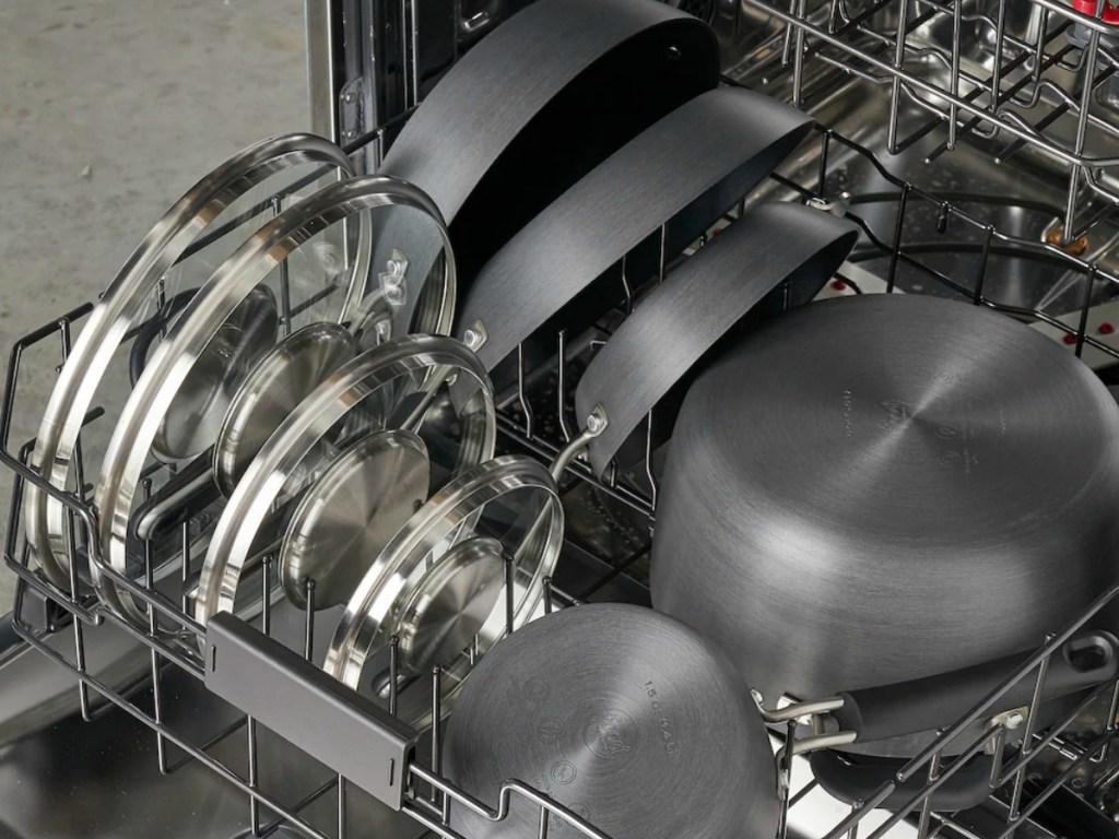 large set of gray cookware set in dishwasher with coordinating lids