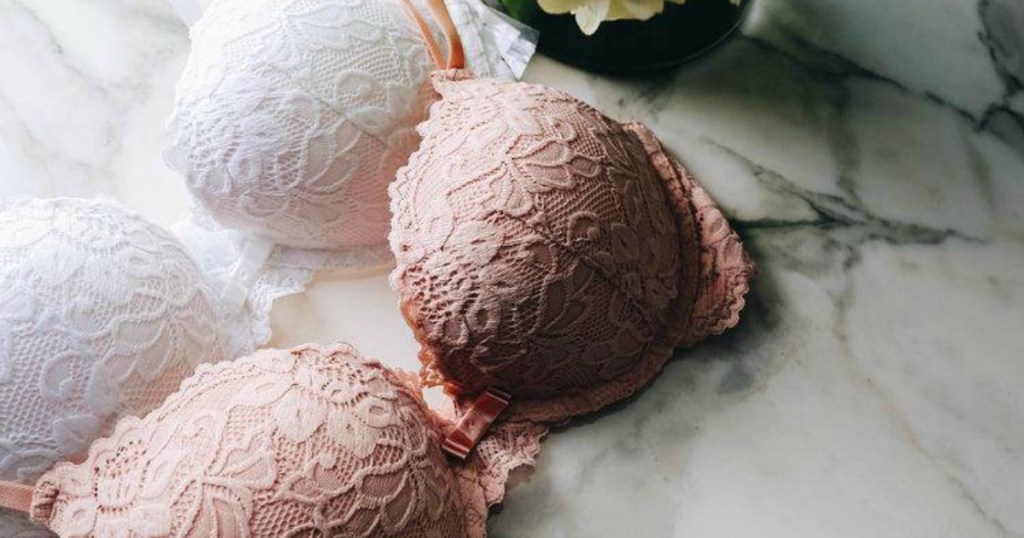 Two colors of lace push-up bras on white marble counter