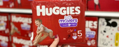Hand holding up Huggies Diapers