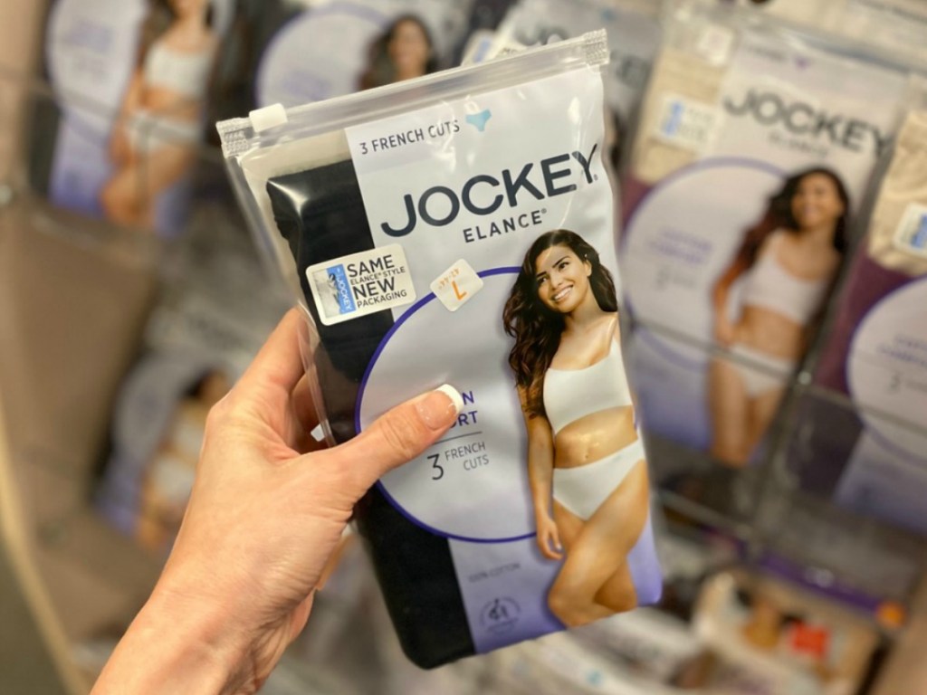 Women's package of brief panties in hand near in-store display