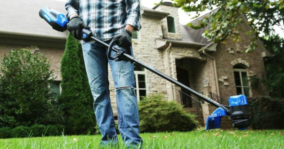 man holding a Kobalt trimmer