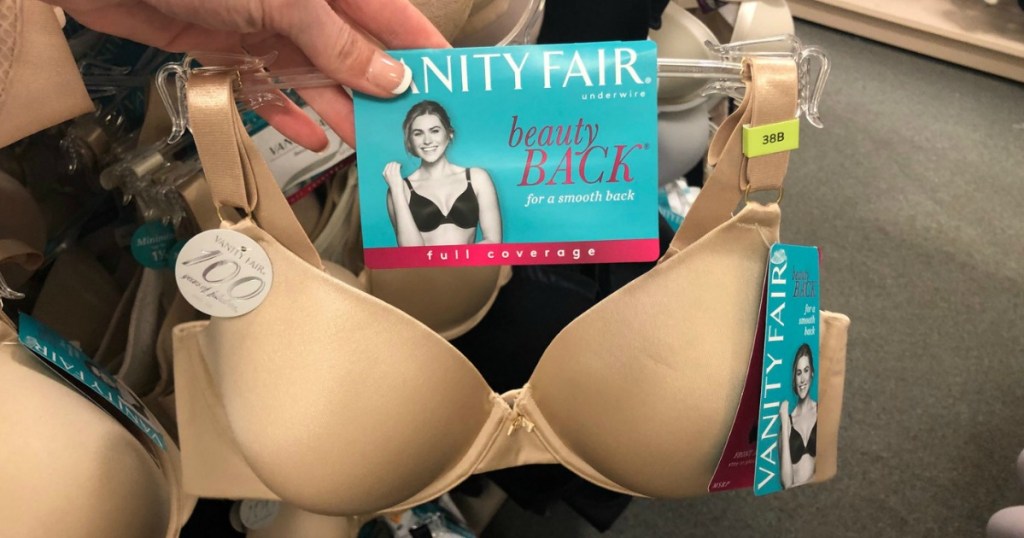Full coverage beige bra on hanger near in-store display of intimates