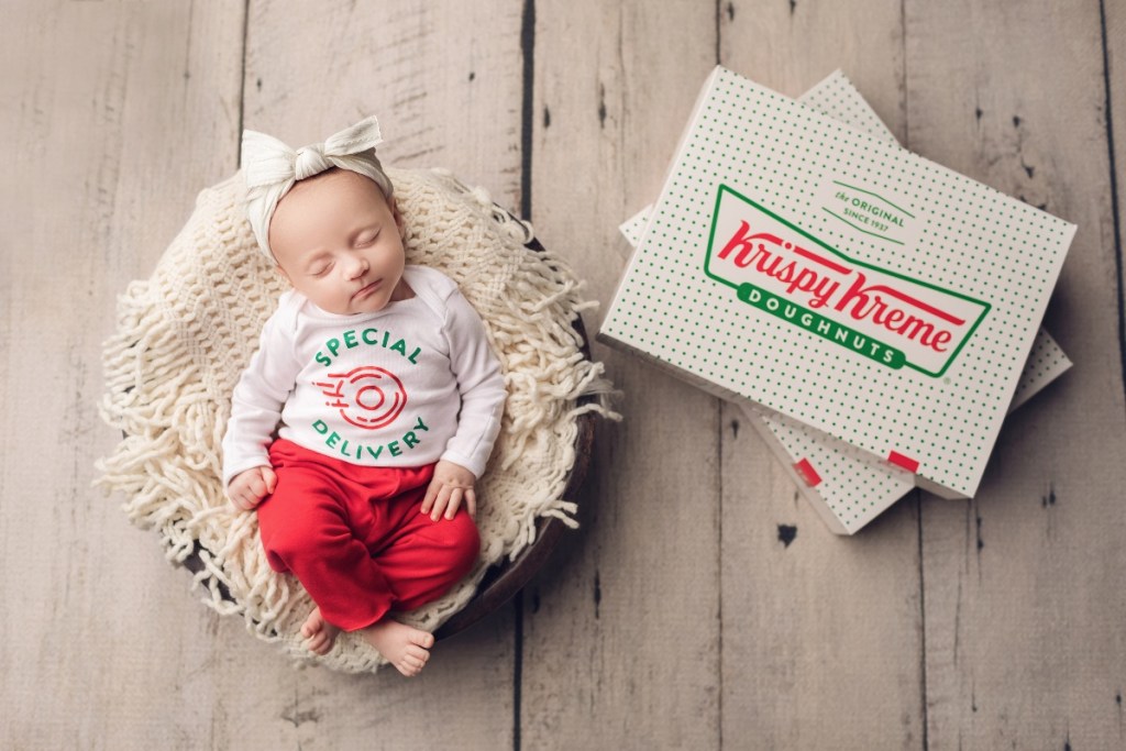 baby with boxes of Krispy Kreme doughnuts