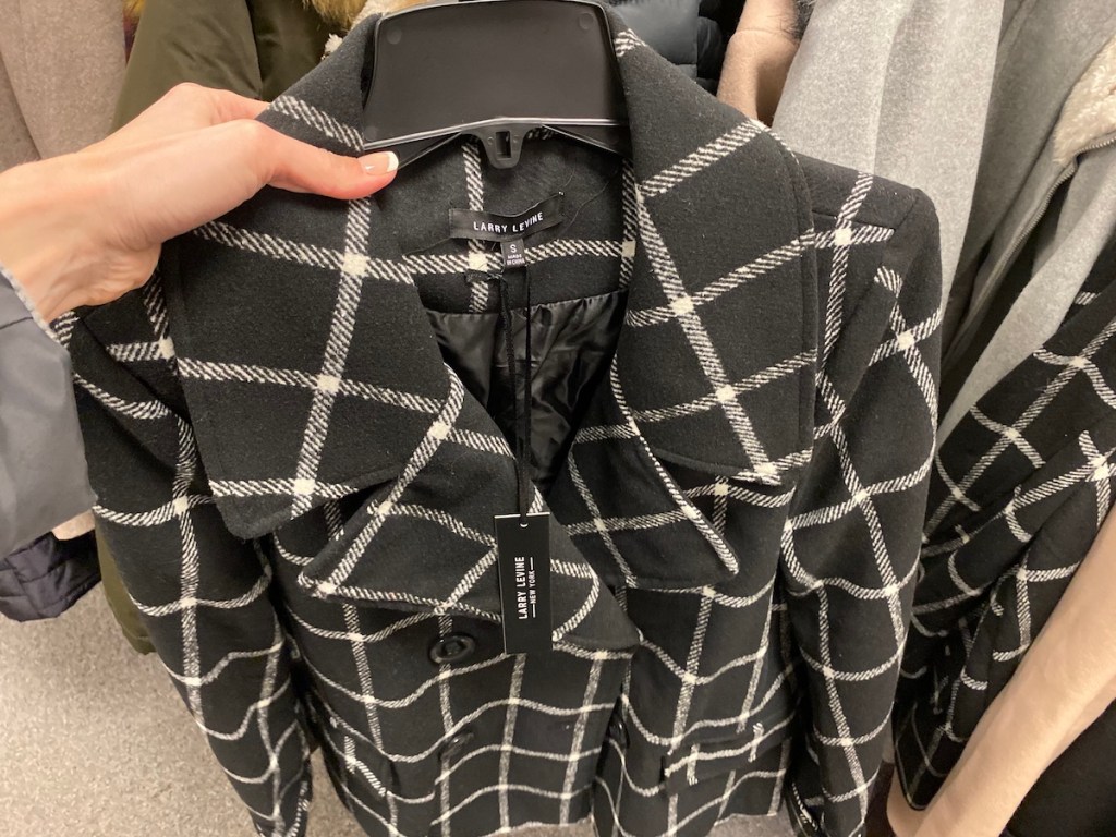 hand holding a black coat on a hanger